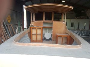 Rear view image of wooden boat in workshop